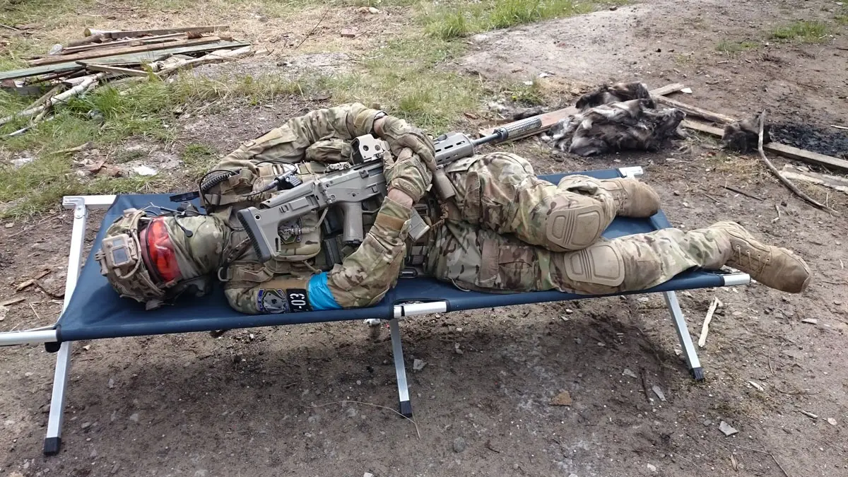 Pathogen liegt erschöpft auf einem Feldbett im Freien.